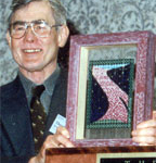 Theodore Roszak holding beaded Quilt award